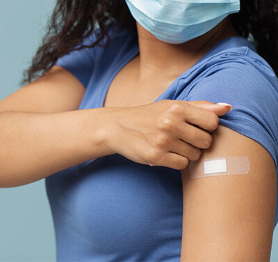 Woman showing arm with bandaid after vaccine
