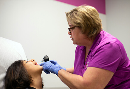Hygienist checking girl patient's mouth